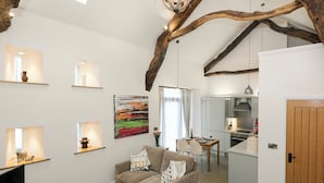 Un soggiorno con un divano, un tavolino, una televisione e un quadro appeso al muro.