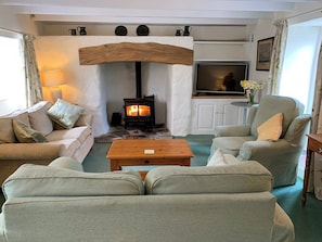 A cozy living room with a fireplace, sofas, a coffee table, and a television. - 3 bedroom accommodation in Manaccan, near Helston (Manaccan, near Helston)