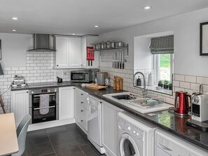 A modern kitchen with white cabinetry, a built-in oven, a microwave, a sink, and a dishwasher. - 1 bedroom accommodation in Garth, near Builth Wells (Garth, near Builth Wells)