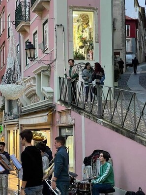 Vista de una calle con edificios, una escalera y gente.