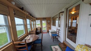 A cabin with a dining area, a seating area, and a view of the water. - Lake House getaway!!! 2-bedroom Cayuga Lake, lake front property! (Seneca Falls)