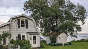 A house with a front yard, a small shed, and a large tree. - Lake House getaway!!! 2-bedroom Cayuga Lake, lake front property! (Seneca Falls)