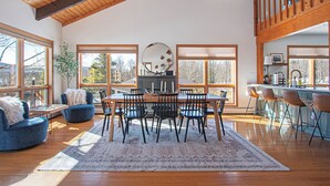 Un grand espace de vie comprenant une table à manger, des chaises, un canapé et un coin cuisine.