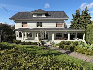 A two-story house with a porch, a covered front entrance, and a well-maintained garden. - World Cup Headquarters! Perfect for large groups! (Seattle)