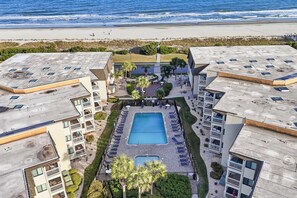A hotel with a central swimming pool, multiple balconies, and a view of the beach. - Golden Mile Oceanview Retreat (Myrtle Beach)