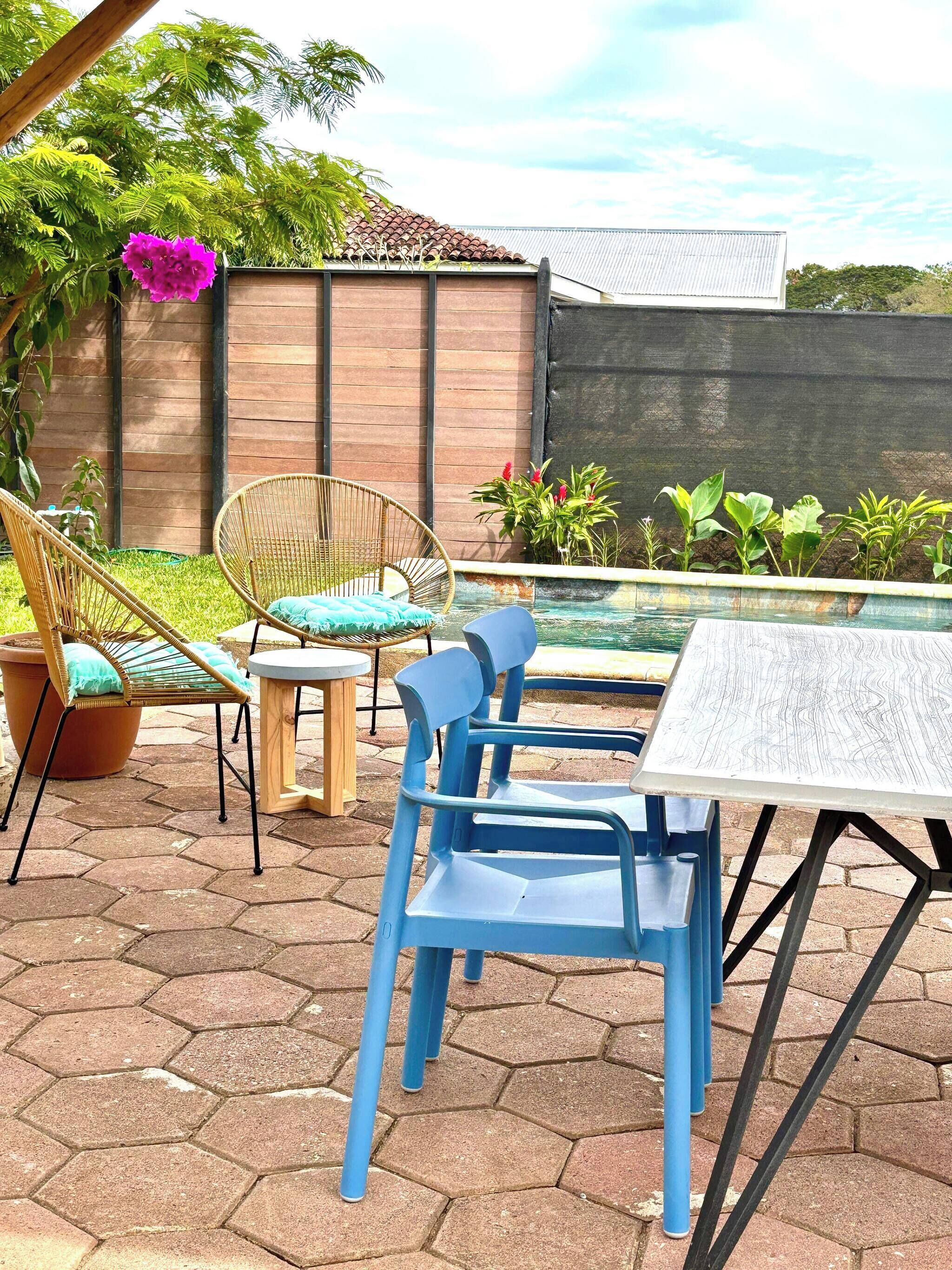 A patio area with a pool, outdoor furniture, and a wooden fence.