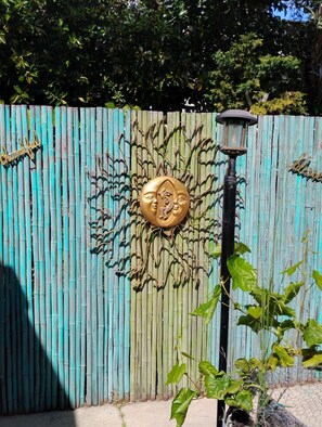 Una valla de bambú con detalles decorativos, un letrero de metal que dice 'thankful' y un farol.