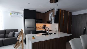 Une cuisine moderne dotée d’un îlot central, de meubles en bois foncé et d’un four encastré.