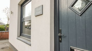 Un edificio con un letrero que dice 'Corner House' y una puerta con un rótulo que indica 'ESTACIONAMIENTO PRIVADO, SOLO AUTORIZADO'.