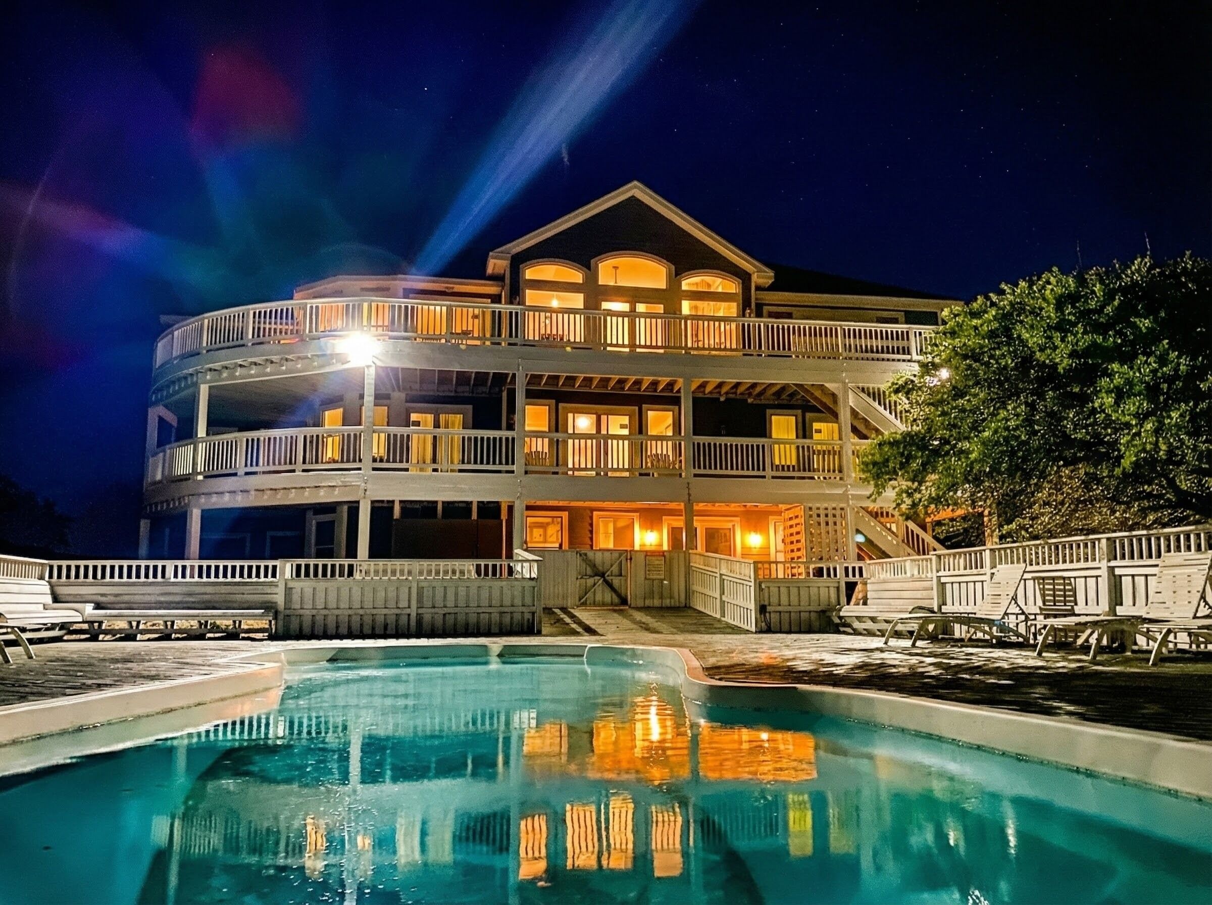 A multi-story building with a pool in front.