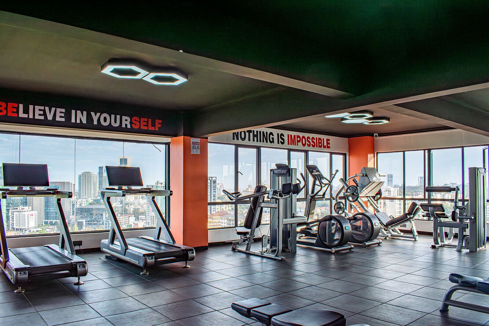A gym with treadmills, weight machines, and motivational posters.