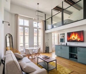 Ein modernes Wohnzimmer mit einer Couch, einem Couchtisch und einem an der Wand befestigten Fernseher.