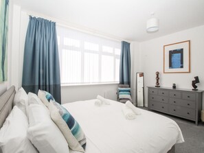 A hotel room with a bed, a dresser, a mirror, and a window with curtains. - Portland View (Portland)