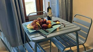 Ein Esstisch mit einer Weinflasche, Gläsern und Obst.