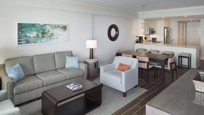 Un salon moderne comprenant un canapé, un fauteuil, une table basse et un coin repas.