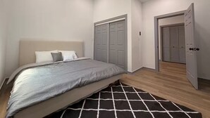 A bedroom with a bed, a closet, and a door. - Modern Stay Next to Downtown  Sleeps 7 (San Antonio)