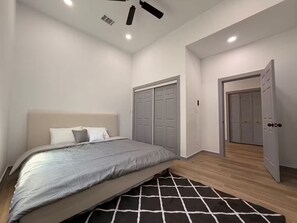 A bedroom with a bed, a closet, and a door. - Modern Stay Next to Downtown  Sleeps 7 (San Antonio)