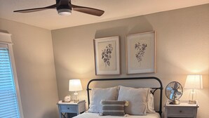A bedroom with a bed, nightstands, a ceiling fan, and framed artwork on the wall. - Highly Rated Farm Cottage · Weatherford TX · 30 Min to Fort Worth (Weatherford)