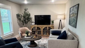 A living room with a sofa, armchairs, a coffee table, a TV, and a ceiling fan. - Highly Rated Farm Cottage · Weatherford TX · 30 Min to Fort Worth (Weatherford)