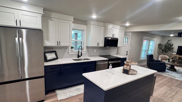 A modern kitchen with white cabinets, stainless steel appliances, and a central island. - Highly Rated Farm Cottage · Weatherford TX · 30 Min to Fort Worth (Weatherford)