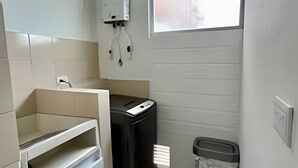 A compact bathroom with a toilet, sink, and trash bin. - 802 santa elena (Medellín)