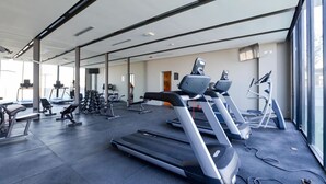 Ein Fitnessstudio mit Laufbändern, Kraftgeräten und verschiedenen Trainingsmöglichkeiten.