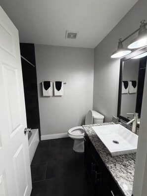 A bathroom with a white sink, a toilet, a towel rack, and a mirror. - Comfy 2x1 Apt. Next to Mueller and Downtown (Austin)