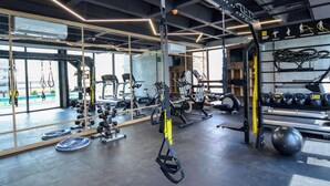 A gym with exercise equipment, weight racks, and a large window. - ¡Alberca y Gym! / Barrio W / 2 personas #Centro (Monterrey)