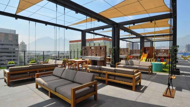 A rooftop terrace with outdoor seating, a bar area, and a view of the cityscape. - ¡Alberca, gym y asadores! / Barrio W / 4 personas (Monterrey)