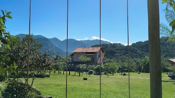 Um balanço em uma área gramada, com um edifício ao fundo.