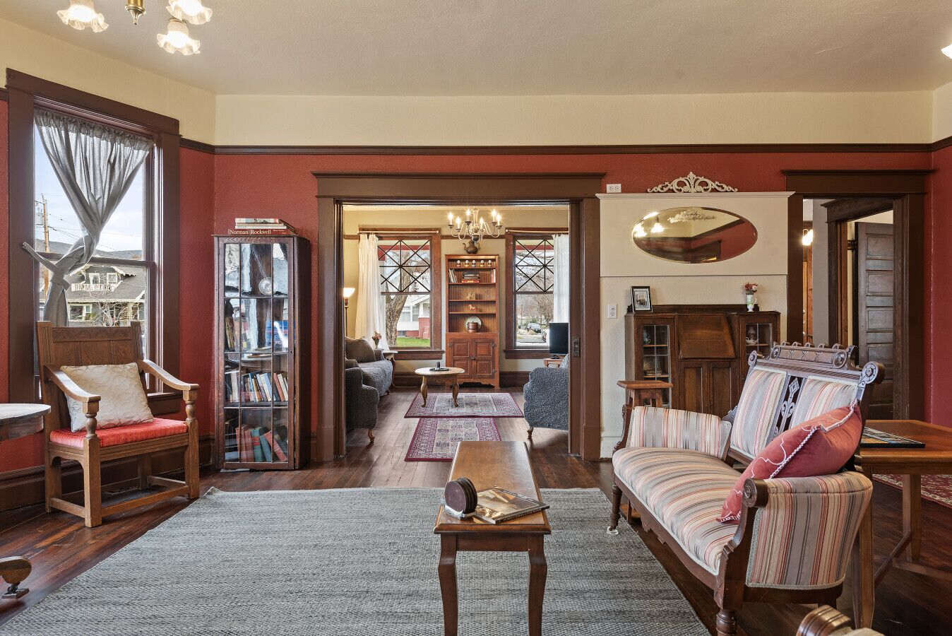 A cozy living room with a fireplace, a bookshelf, a sofa, and a dining table.