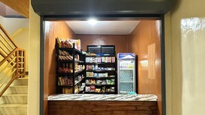 Ein kleiner, abgeschlossener Verkaufsbereich mit Regalen voller Snacks und einer Kühltruhe.