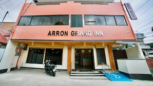 Un bâtiment à deux étages, avec une enseigne indiquant « ARRON GRAND INN » sur la façade.