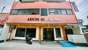 Un bâtiment à deux étages, avec une enseigne indiquant « ARRON GRAND INN » sur la façade.