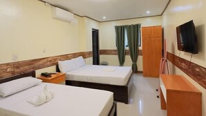 Une chambre d’hôtel avec deux lits, une télévision, un bureau et une armoire.