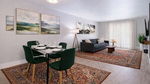 A modern living room with a dining area, featuring a sofa, dining table, and artwork on the walls. - Chic South Tampa Retreat  2 King Beds  Pool, Gym & Prime Walkable Location (Tampa)