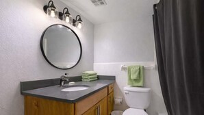 A bathroom with a sink, mirror, toilet, and a bathtub. - Chic South Tampa Retreat  2 King Beds  Pool, Gym & Prime Walkable Location (Tampa)