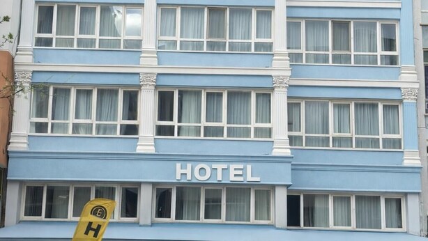 A multi-story hotel building with a blue facade, large windows, and a prominent 'HOTEL' sign. - Elit öztürk otel (Ankara)