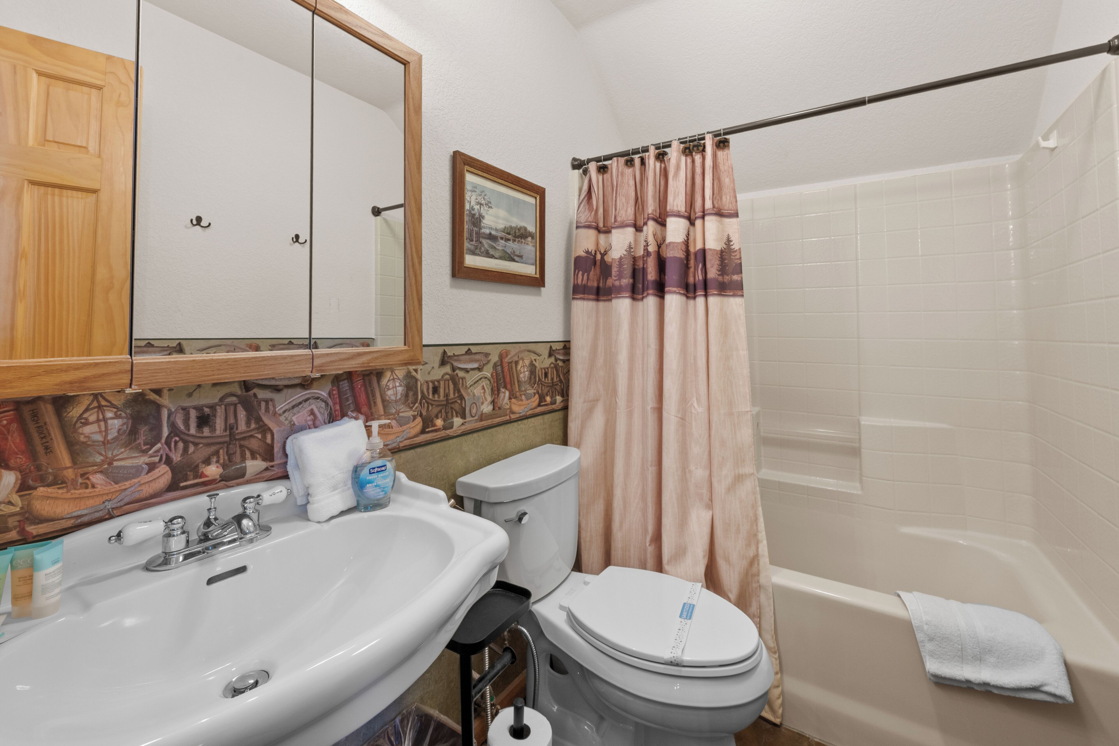 Un baño con lavamanos, inodoro y bañera.