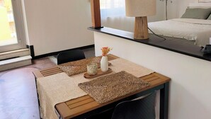 A modern interior with a dining area featuring a wooden table, black chairs, and woven placemats. - Casa Adamo- Rooftop Hideaway (Genova)