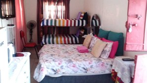 A bedroom with a bed, a chair, a fan, a wardrobe, and a desk with a computer. - Room-hollywood Lodge & Green Jewel Adven (Nama Khoi)