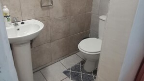 A bathroom with a white sink, toilet, and a shower area. - Room-hollywood Lodge & Green Jewel Adven (Nama Khoi)