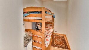 A bunk bed with a plush toy on the lower bunk, a small table with a glass, and a patterned rug on the floor. - Wifi, 100m from ski slopes, 1st floor, balcony, tv, ski locker, 81m², Les Gets (Les Gets)