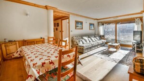 A room with a bed, a sofa, a TV, and a window with a view. - Wifi, 100m from ski slopes, 1st floor, balcony, tv, ski locker, 81m², Les Gets (Les Gets)