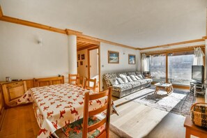 Ein Zimmer mit einem Bett, einem Sofa, einem Fernseher und einem Fenster mit Blick.