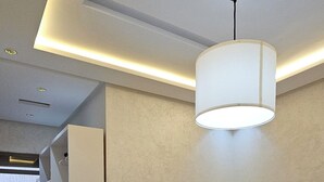 Une chambre avec deux lits, un luminaire au plafond et une armoire intégrée.