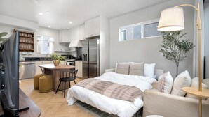 Une chambre à coucher moderne avec un lit, une table de chevet et une lampe.