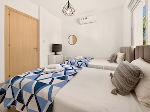 Ein Hotelzimmer mit Bett, Fernseher, Spiegel und Klimaanlage.