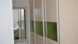 Ein Zimmer mit Bett, Tür und einer Trennwand mit grünen Elementen.