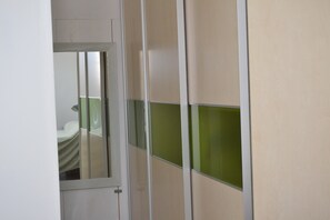 Ein Zimmer mit Bett, Tür und einer Trennwand mit grünen Elementen.